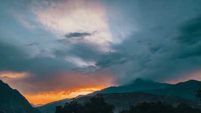 日落时多云天空下的山脉轮廓